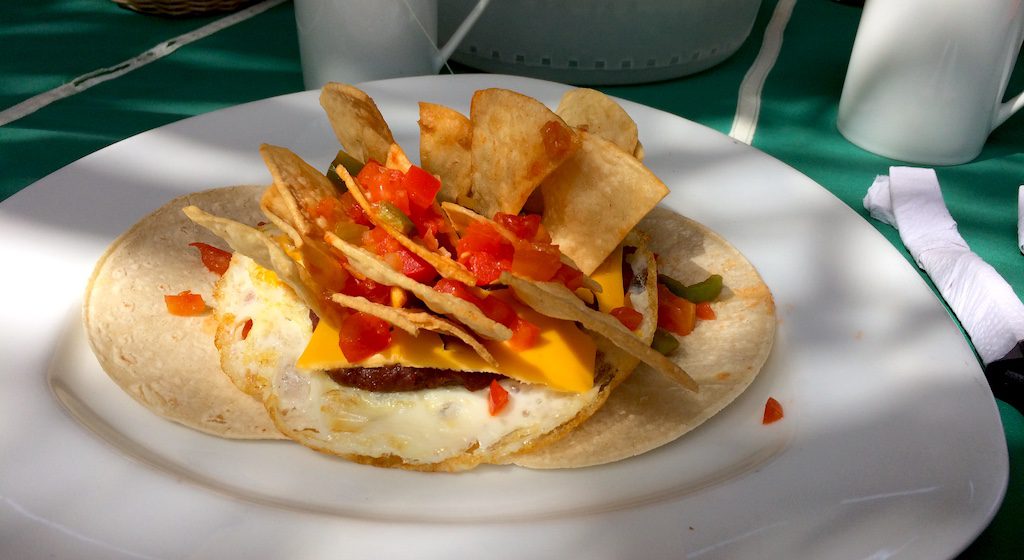 Frühstück in El Salvador, Nachos, Tomaten, Käse, Ei und Bohnenpürree auf kleinen Tortillafladen